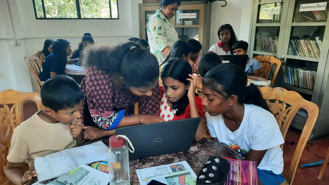 Kinderen werken samen achter een laptop tijdens de computerles