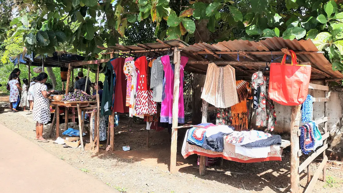 Kleding en stoffen te koop op de weekmarkt in het dorp